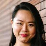 asian-woman-leaning-on-wall Young dark-haired Asian woman leaning on a wooden wall.